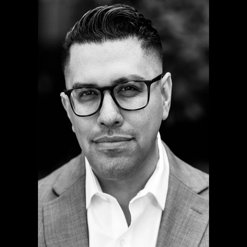 Black-and-white headshot of man wearing glasses