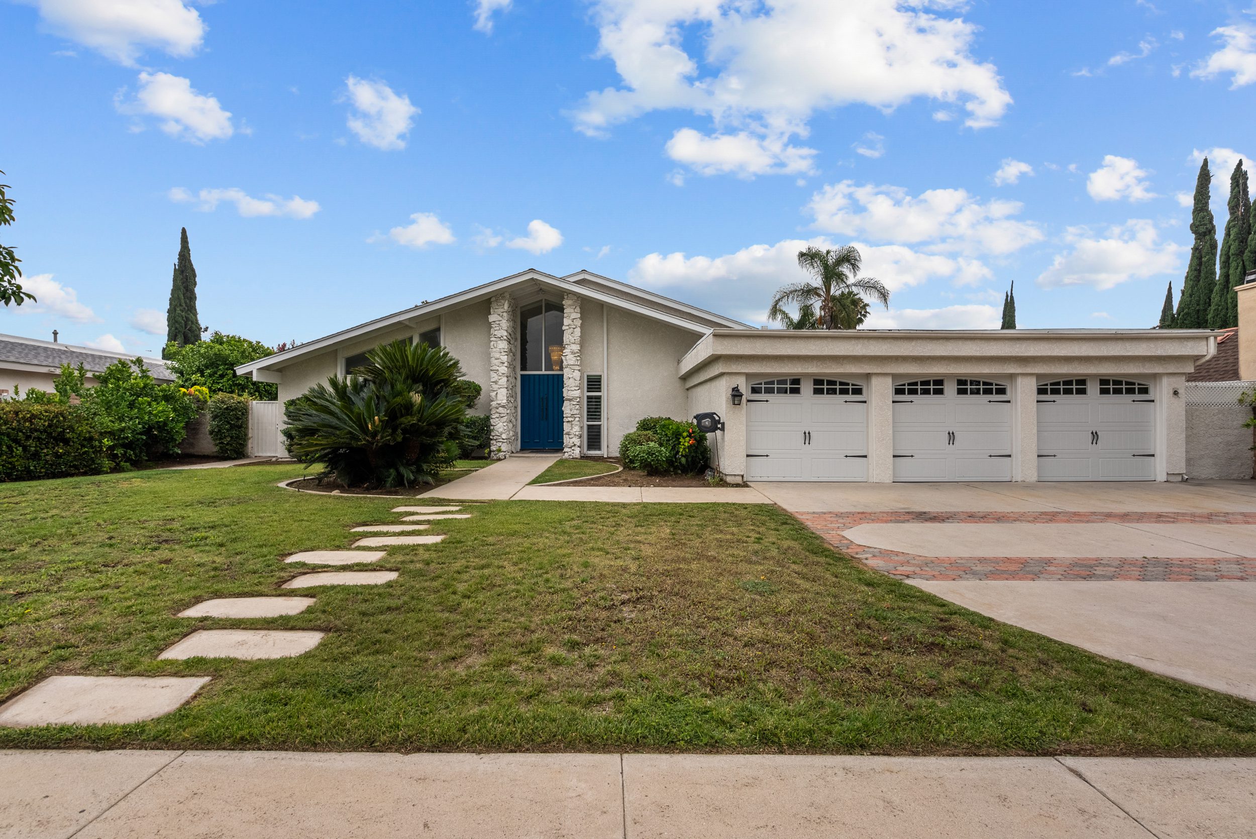 Ranch house with blue door, three-car garage